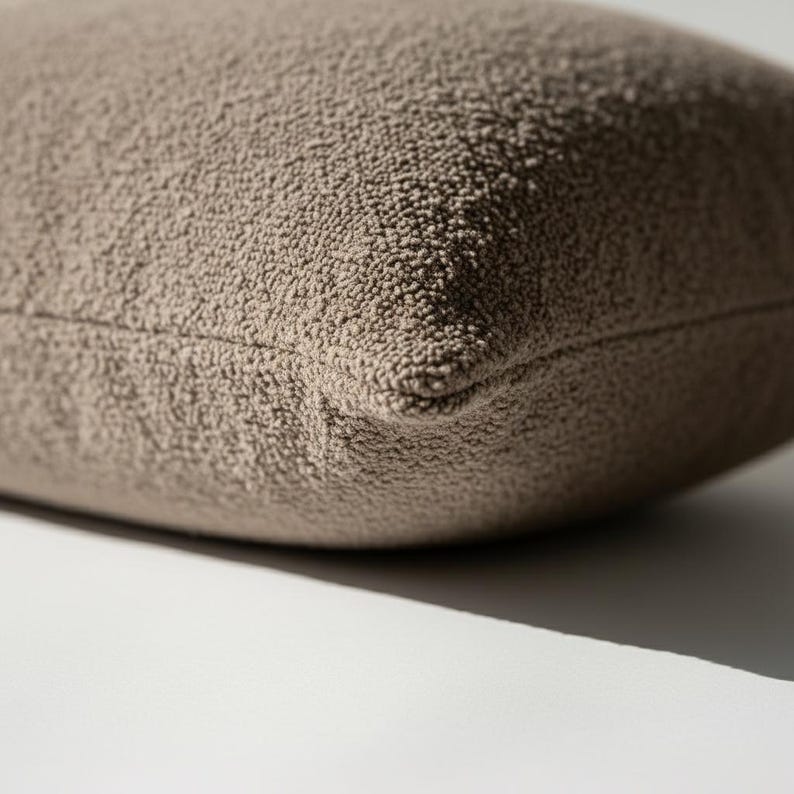 Bottom edge of brown boucle pillow cover showing hidden zipper closure