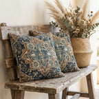 Two Persian chenille throw pillow covers on a rustic wooden bench with a woven basket of dried pampas grass decor.