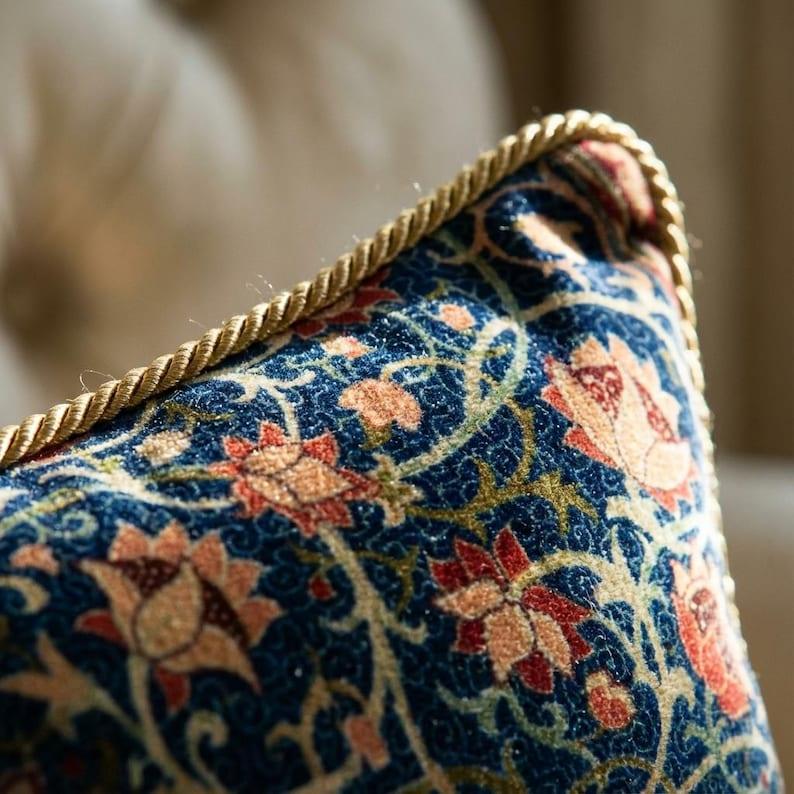 Close-up of gold braided rope trim on William Morris velvet throw pillow cover with coral and navy floral pattern