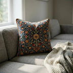 William Morris botanical velvet throw pillow cover on a grey sofa, intricate scrolling vine and floral print with gold rope trim
