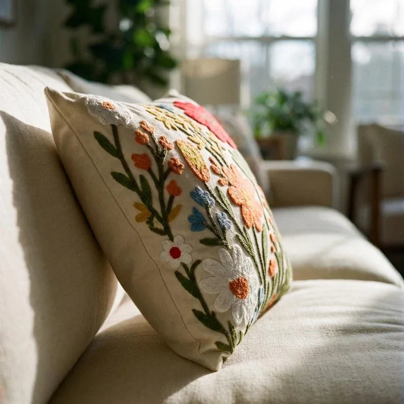 Floral embroidered pillow cover on beige linen sofa in bright living room — artisan home decor
