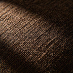 Macro shot of the tightly woven brown chenille fabric, showcasing its intricate texture and subtle thread variations.