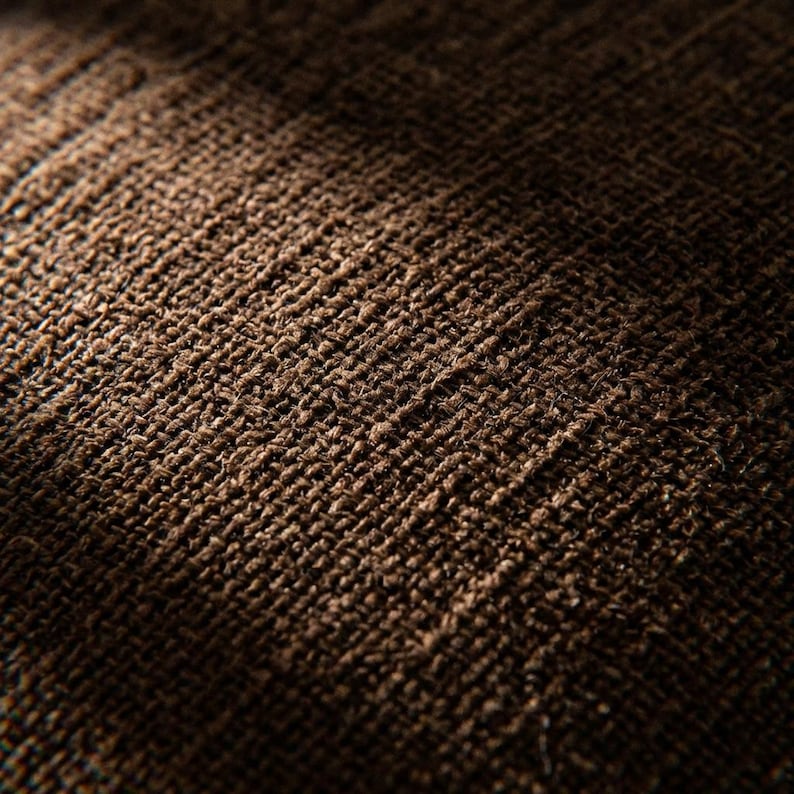 Macro shot of the tightly woven brown chenille fabric, showcasing its intricate texture and subtle thread variations.