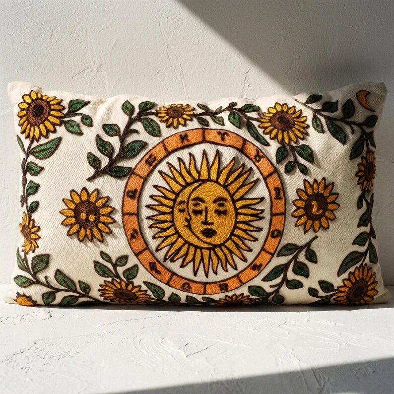 Embroidered celestial sun lumbar pillow cover with sunflower and zodiac motifs on off-white cotton canvas