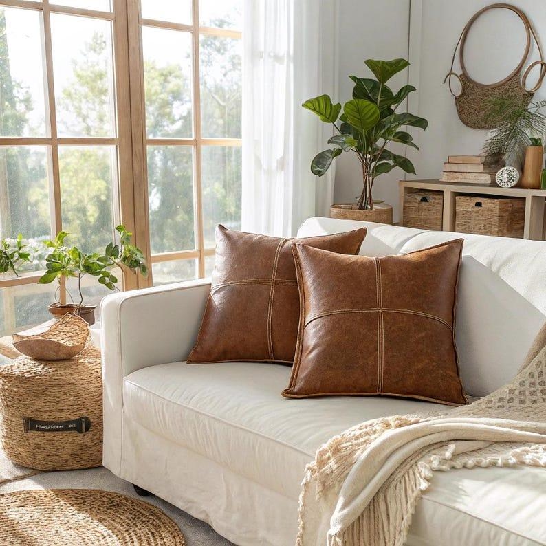 Two brown vegan leather throw pillow covers styled on white sofa in bright boho living room