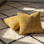 Two yellow textured pillows on a patterned rug