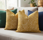 Yellow textured pillows on a sofa with a neutral background