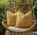 Woven chair with yellow patterned cushions in a natural setting