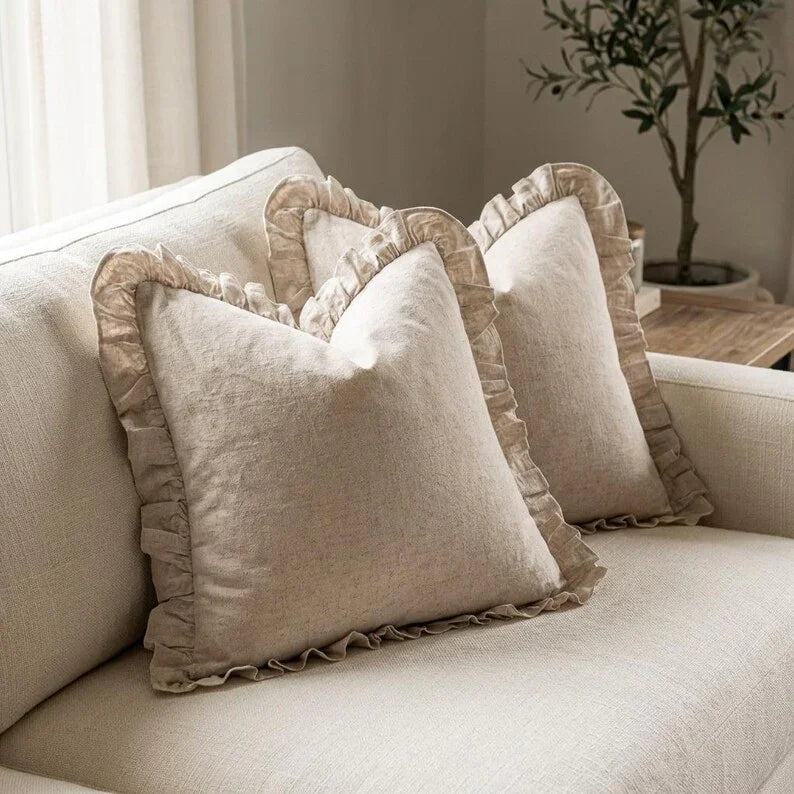 Set of 2 linen ruffle pillow covers on a white sofa in a farmhouse-style living room
