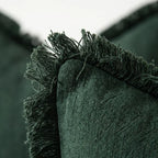 Close-up of linen fringe trim corner detail on olive green pillow cover showing slub texture and handcrafted edge