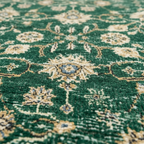 Close-up of green Oushak rug showing distressed floral medallion pile texture