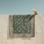 Green Turkish-style vintage area rug with cream and gold floral border detail