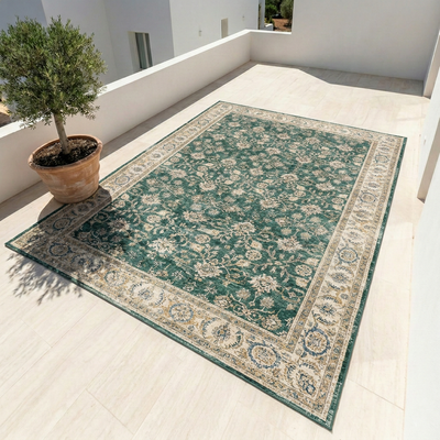 Green vintage Oushak area rug with distressed floral pattern on outdoor terrace
