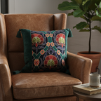 Embroidered floral velvet throw pillow cover with tassels styled on a brown leather armchair in a living room