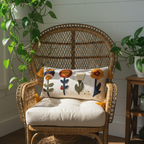 Handcrafted punch needle lumbar pillow cover with tassels on rattan peacock chair — cottagecore boho porch decor