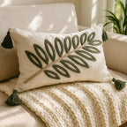 Forest green leaf punch needle lumbar pillow cover styled on a beige sofa with chunky knit throw