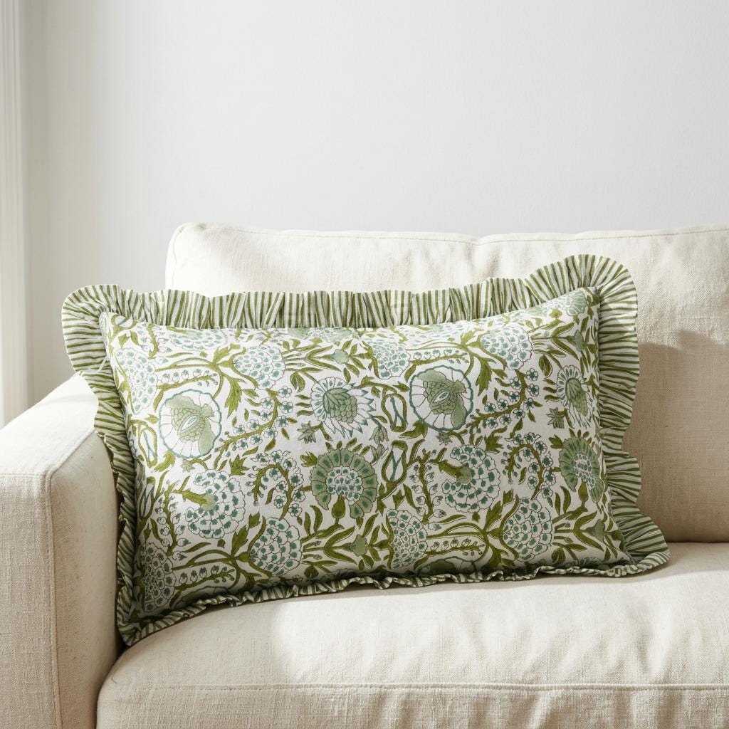 Artisan floral block print bolster pillow cover with striped ruffle trim on a cream sofa — close view
