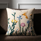 Artisan embroidered wildflower pillow cover with hummingbird motif on ivory cotton canvas, styled on a gray linen sofa