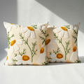 Two daisy floral embroidered pillow covers side by side showing raised tufted texture and green embroidered stems