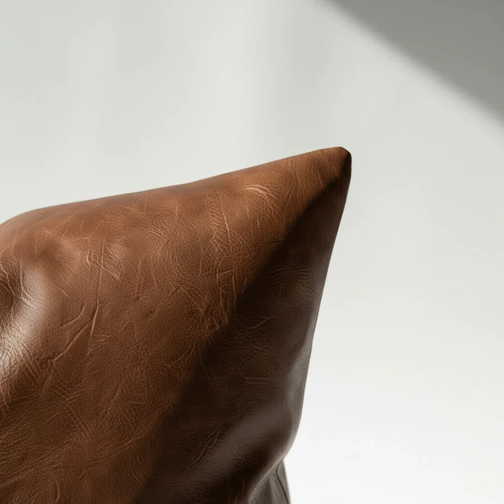 Detail shot of distressed vegan leather pillow cover surface with natural crinkle finish in warm brown