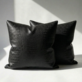 Set of 2 black crocodile embossed vegan leather throw pillow covers on white surface
