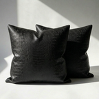 Set of 2 black crocodile embossed vegan leather throw pillow covers on white surface