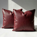 Set of 2 burgundy vegan leather throw pillow covers on white surface, modern home decor
