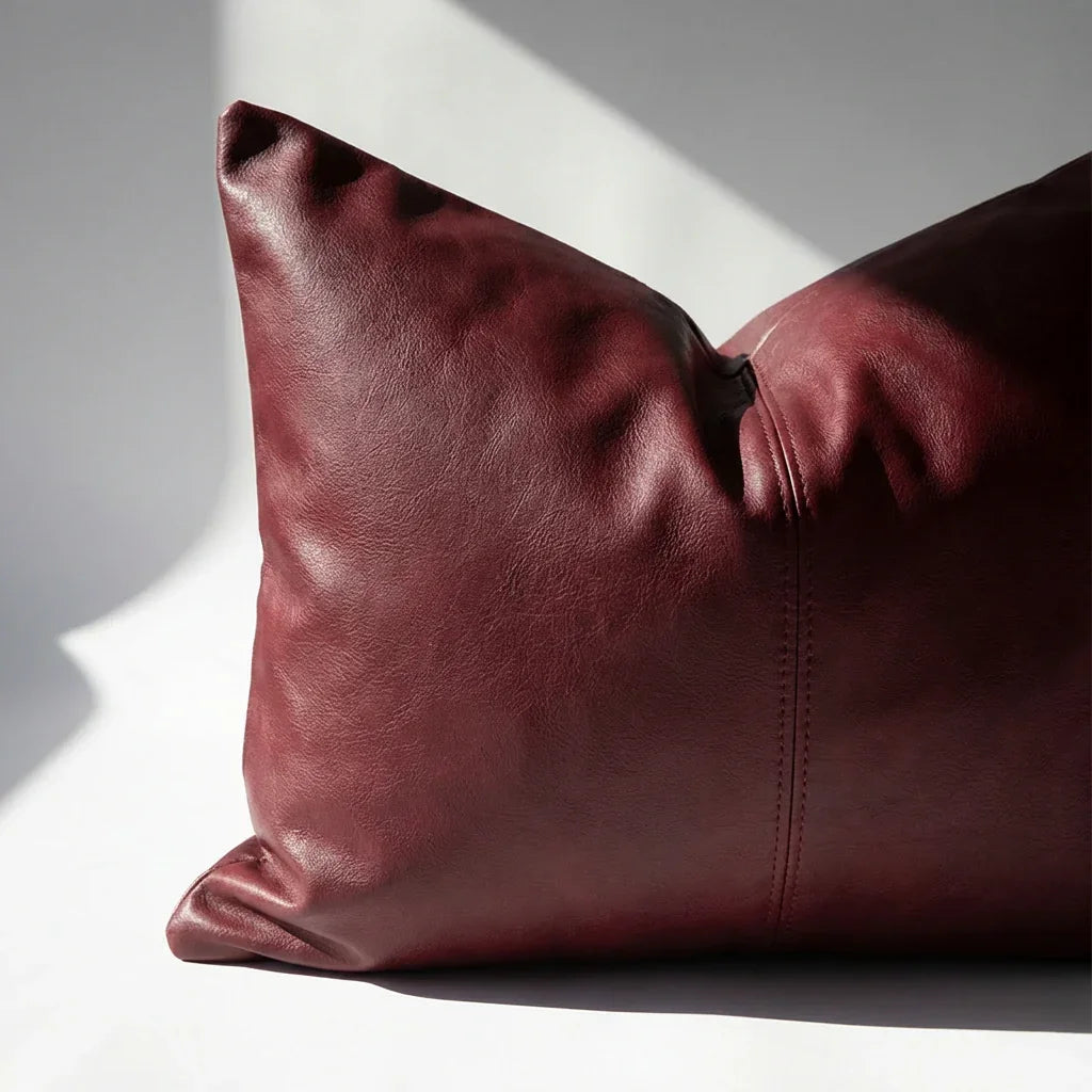 Close-up of burgundy vegan leather pillow cover corner showing hidden zipper detail