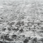 Macro texture shot of gray vintage distressed rug showing charcoal and light gray faded pile surface
