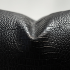 Macro texture detail of black crocodile embossed vegan leather pillow cover surface