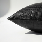 Close-up corner detail of black crocodile embossed vegan leather pillow cover showing zipper closure