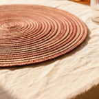 Close-up of braided spiral pattern on round jute placemat in wine – Larissa Home Decor