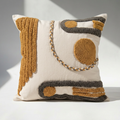 Punch needle tufted abstract throw pillow cover in mustard ochre and charcoal on cream cotton canvas, styled on white surface
