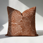 Single tufted burnt orange chenille pillow cover with geometric swirl design, front view