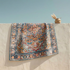 Vintage floral medallion washable rug draped over a wall showing full pattern detail