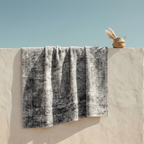 Gray distressed washable area rug draped over white wall showing abstract faded pattern detail