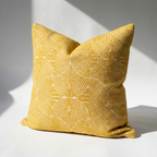 Yellow textured pillow on a light gray background